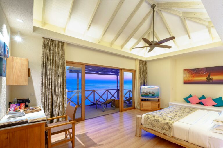 Cozy modern beachside room with stunning ocean sunset view, ideal for relaxation.